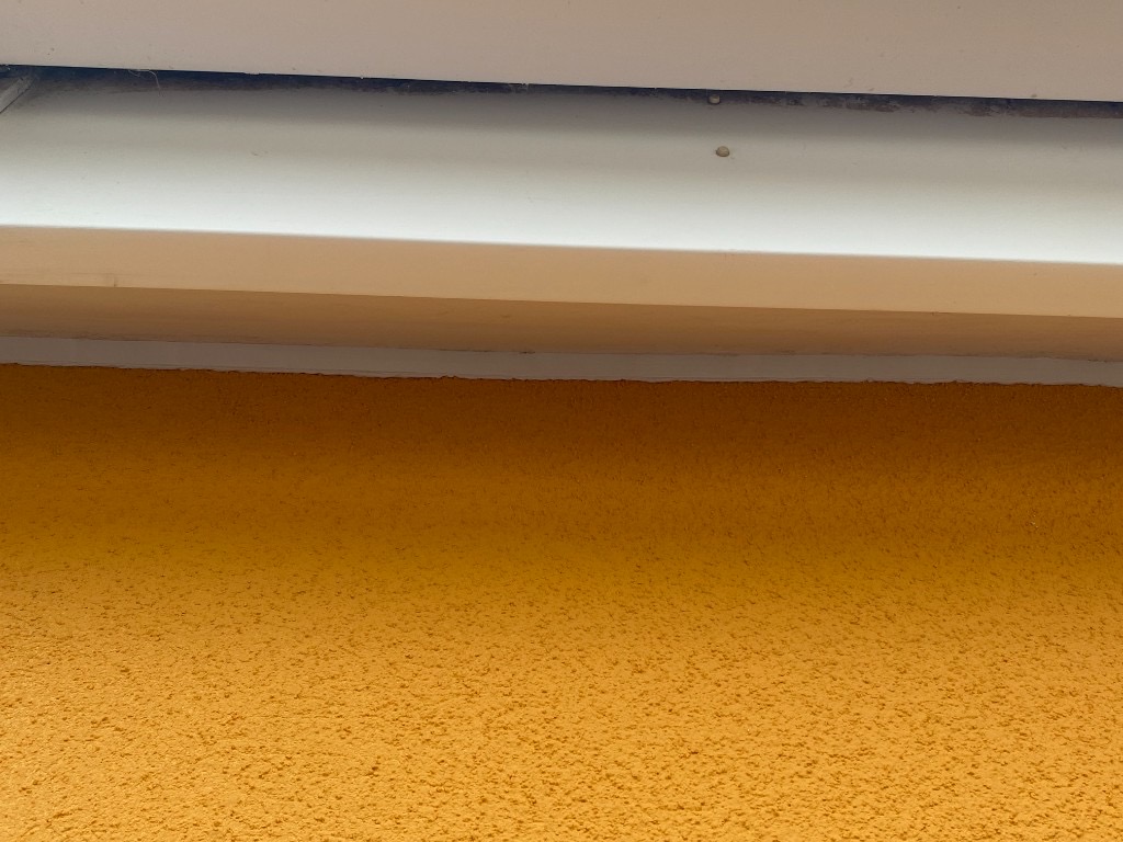 Fresh white sealant bead along render and soffit joint after professional resealing