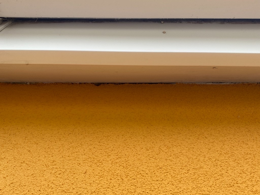 Open gap between orange render wall and white soffit before resealing in South Wales